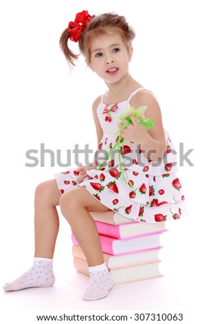 Lovely little girl in a very short summer white dress, eat on the books in the hands of the magic wand . Today the girl is a magician-Isolated on white background
