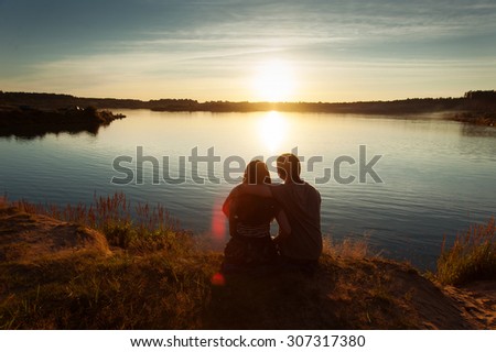 boy and  girl at sunset having embraced in the summer