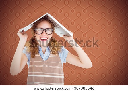 Geeky hipster woman covering her head with her laptop against background