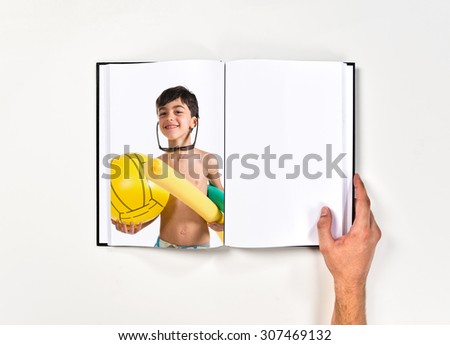 Child holding beach elements printed on book