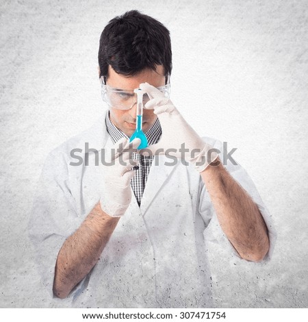 Scientist analyzing a test-tube over grey background