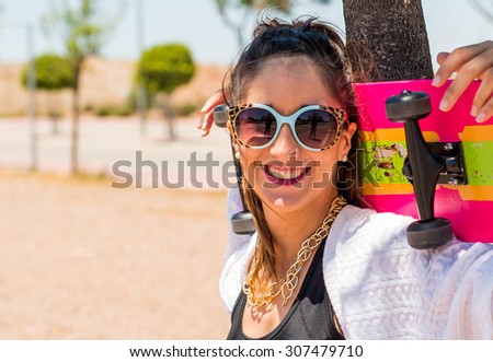 Happy young woman posing with her skateboard