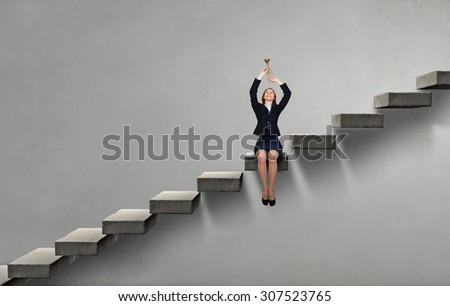 Young businesswoman on staircase proclaiming something in horn