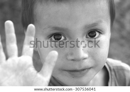 Boy saying stop, stop sign or saying good buy, hello child, kid portrait black and white, child open hand
