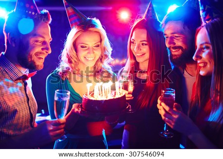 Young people around birthday cake