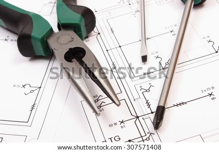 Metal pliers and screwdriver on electrical construction drawing of house, work tool and drawing for projects engineer jobs, concept of building house