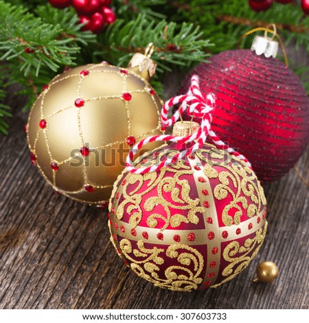three christmas balls   with fir tree on wooden background