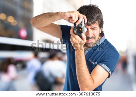 Man photographing on unfocused background