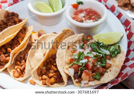 Beef and pork tacos with chopped tomato, onion and lemon