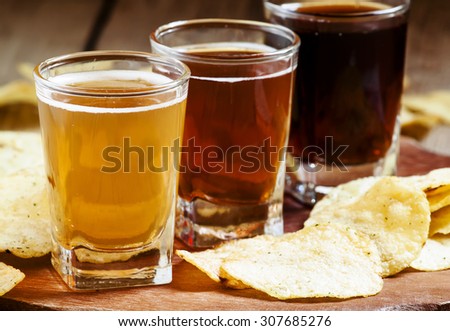 Three kinds of beer and potato chips, selective focus