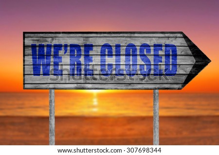 We're Closed wooden sign with on a beach background
