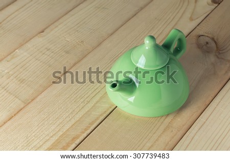 traditional eastern green teapot on wood background