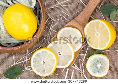 Lemons in spoon on burlap sack background