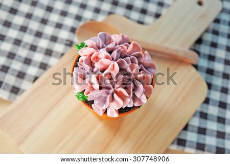 Sweet cupcake on a wooden vintage background. Toned image.