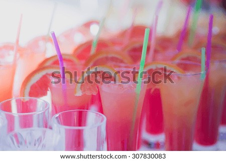 Beautiful row line of different colored alcohol cocktails with mint on a open air party, tequila, martini, vodka with bubbles,and others on decorated catering bouquet table on open air event, picture 