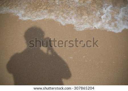 The silhouettes of photographer on the beach in late afternoon sunlight