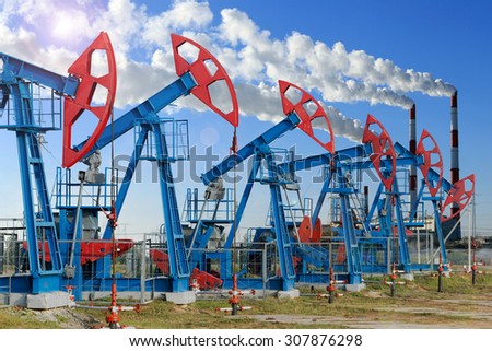close-up of oil pumps on background of dramatic clouds at sunset