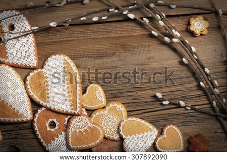  macro gingerbread heart-shaped with a yellow ribbon, flowers on wood background studio