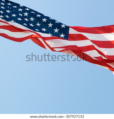 waving american flag over the blue sky