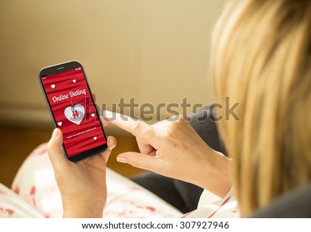 modern relationships concept: mature woman with 3d generated touchscreen smartphone with online dating on the screen. Screen graphics are made up.