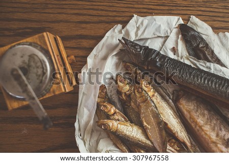 smoked fish on paper, wooden table, pepper mill