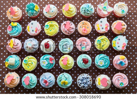 colorful of cup cakes on brown paper