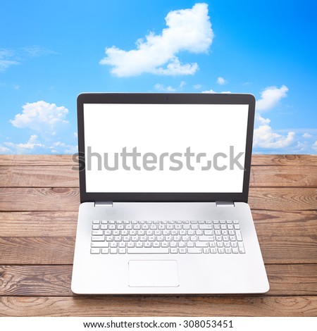 Modern laptop with a white screen on wooden table workplace. Mock up for design. Top view