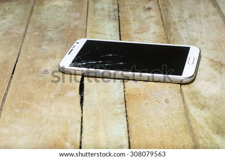 crack Broken glass of smartphone mobile on wood floor