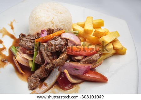 Peruvian food "lomo saltado":A salted beef with tomatoes, onion, fried potatoes and rice. Royalty-Free Stock Photo #308101049