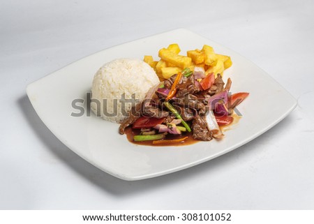 Peruvian food "lomo saltado":A salted beef with tomatoes, onion, fried potatoes and rice. Royalty-Free Stock Photo #308101052