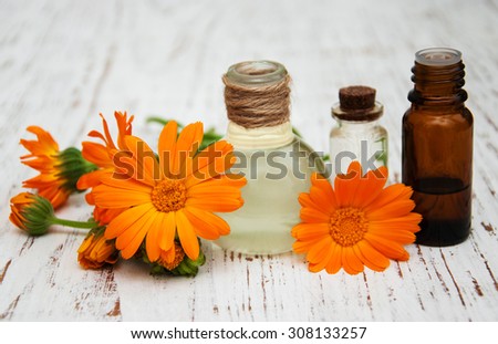 calendula oil in a glass bottles on a old wooden background