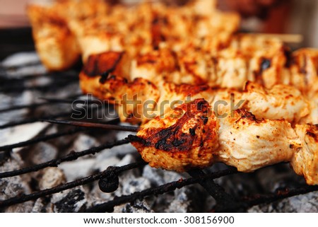 fresh hot grilled chicken shish kebab barbecue on grid over charcoal