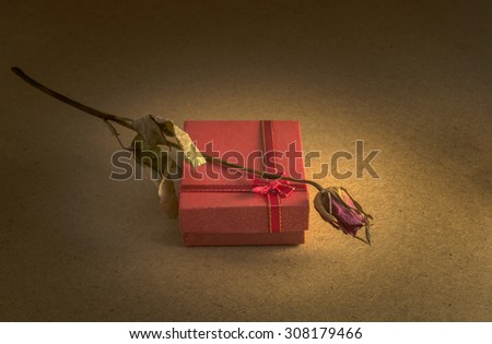Vintage still life . Old roses and old red box in the dark room. Lonely time.
