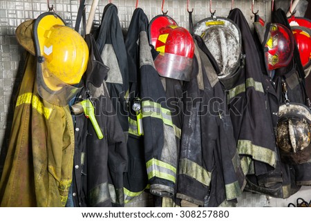 Firefighter suits and helmets hanging at fire station Royalty-Free Stock Photo #308257880