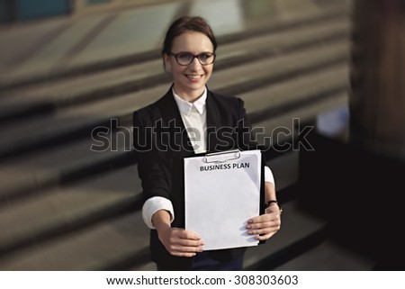 Successful smilling business woman holding documents and clear business plan. Business lady or manager who white business plan.