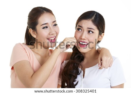 Two Young stylish Girls Having Fun and Taking Photos (Making Selfie) on Smartphone