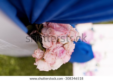 wedding arch decorated with beautiful flowers and blue ribbon. picture with soft focus