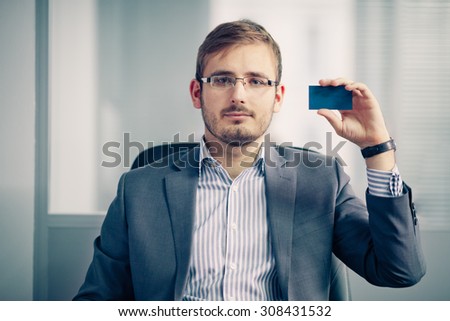 businessman holding empty business card in the office