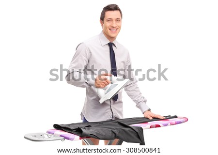 Young man ironing his pants and looking at the camera isolated on white background