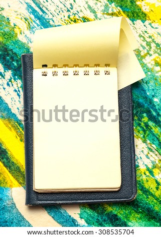 Yellow blank notepad with open page closeup