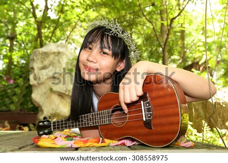 Thai young girl with Ukulele in garden
