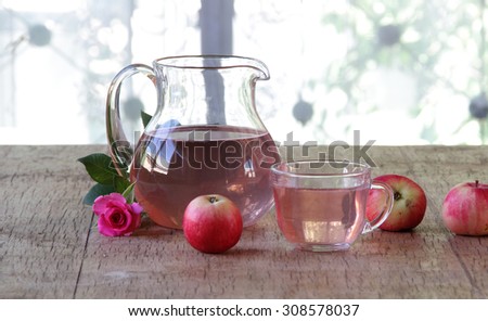 Apple compote in a transparent jug both fresh apples and a rose 