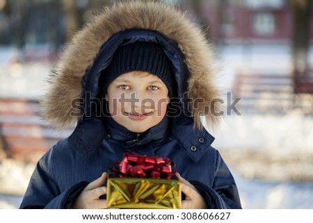 Happy boy with gift box outdoors