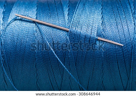 sewing needle in blue thread bobbin close up Royalty-Free Stock Photo #308646944