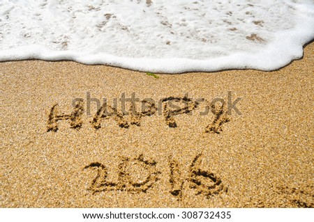 Happy 2016 inscription on the sand near surf line