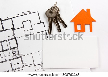 Architectural project, blueprints, silver key with house figure and blank business card on wooden background. Real Estate Concept. Top view.