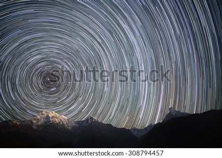 Spinning Universe. Star trails over the mountains. Annapurna South (7,219 m), Hiunchuli (6,441 m),  Gangapurna (7,454 m) and Annapurna III (7.555 m), and unclimbed mountain Machhapuchhre (6,997 m).