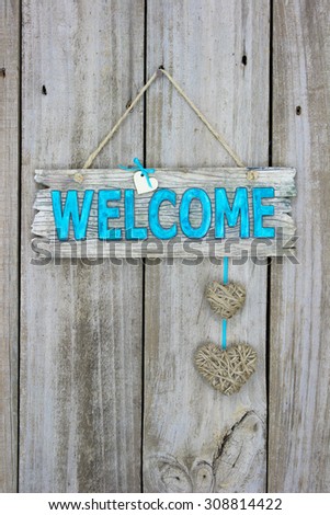 Rustic welcome sign with country rope hearts hanging on antique wooden background