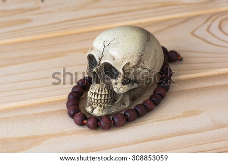 Skull with Paternoster on wood table