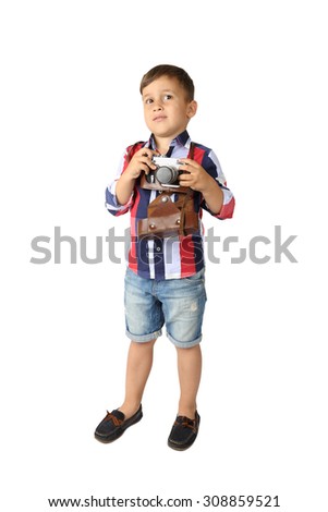 Cute Arabic looking little boy in short jeans stays with vintage camera - full height portrait isolated on white background